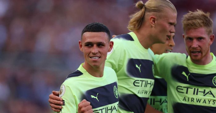 Phil Foden celebrating with Erling Haaland and Kevin De Bruyne