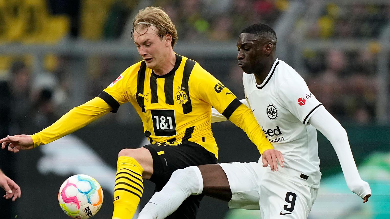 Dortmund's Julian Brandt, left, challenges with Frankfurt's Randal Kolo Muani during the German Bundesliga soccer match between Borussia Dortmund and Eintracht Frankfurt in Dortmund, Germany, Saturday, April 22, 2023