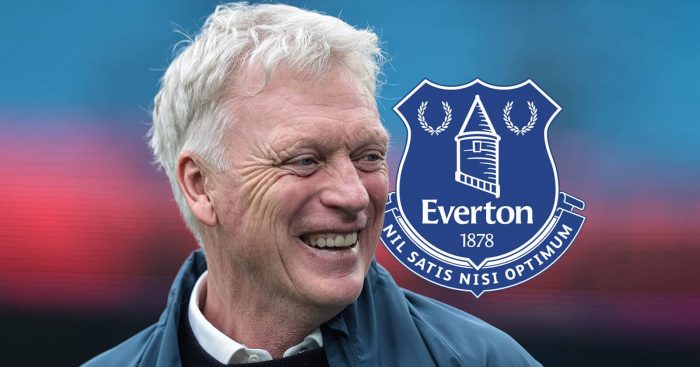 Everton manager David Moyes smiling next to the Everton club crest