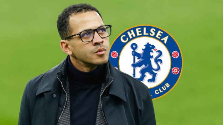 Chelsea manager Liam Rosenior looking thoughtful next to the Chelsea badge
