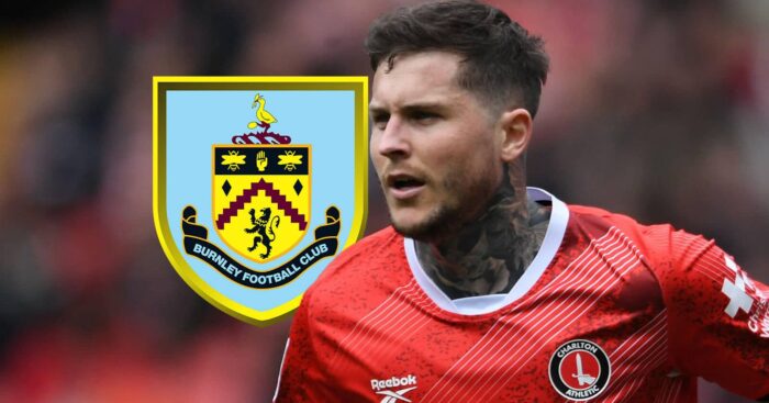 Departing Charlton striker Lyndon Dykes next to the Burnley badge