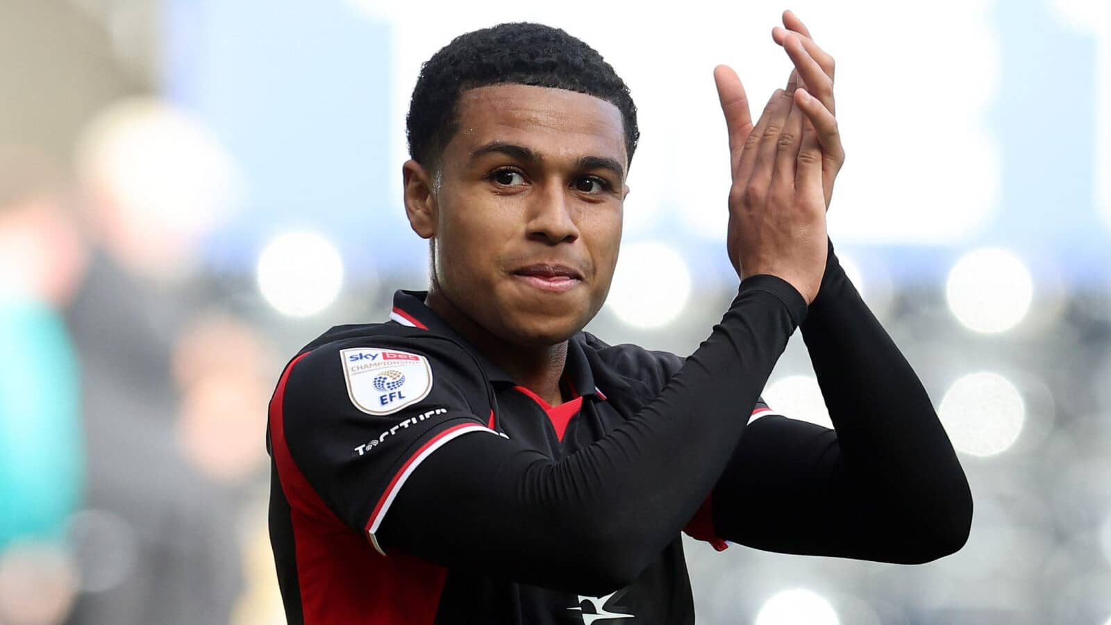 Southampton midfielder Shea Charles claps the travelling fans during a game at Swansea