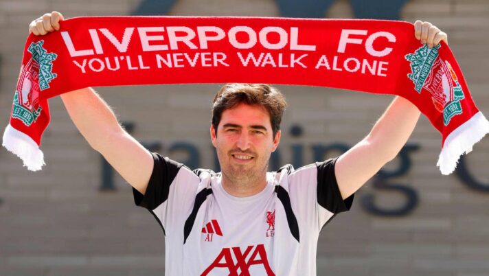 New Liverpool boss Andoni Iraola holds aloft the team's scarf after being presented to the media at their AXA training complex at Kirkby