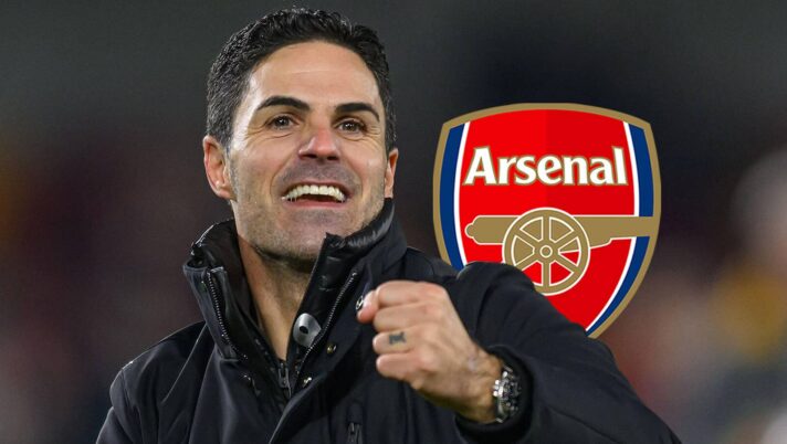 A happy Arsenal manager Mikel Arteta next to the club badge